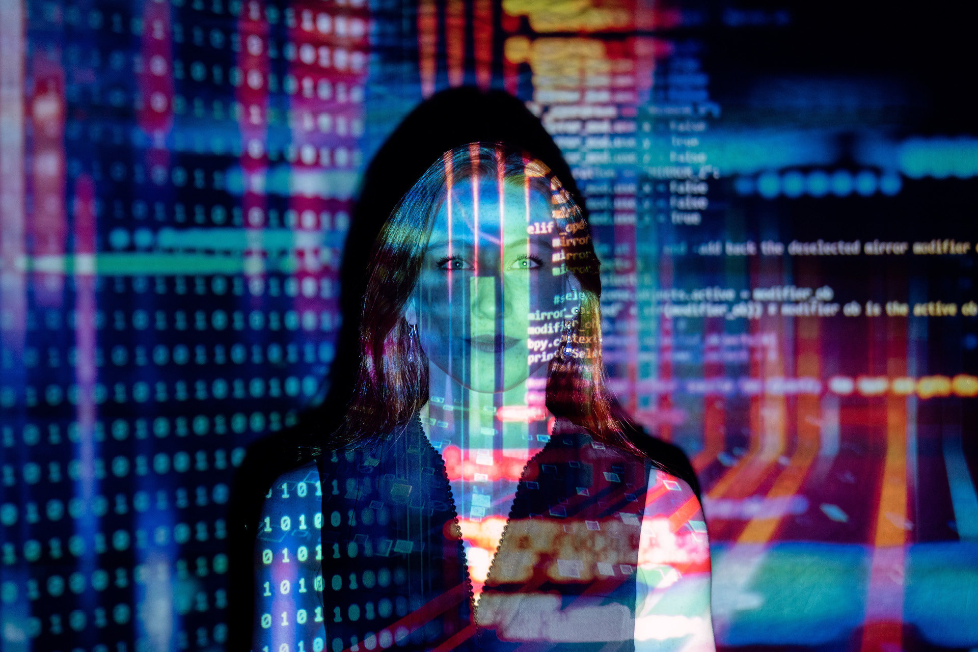 Farbige Informatikdaten werden auf das Gesicht einer Frau projeziert.